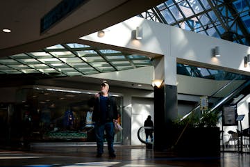 Passersby walk underneath the blocked-off entrance to the third floor in St. Paul’s Town Square on Thursday. The third floor used to have an indoor 