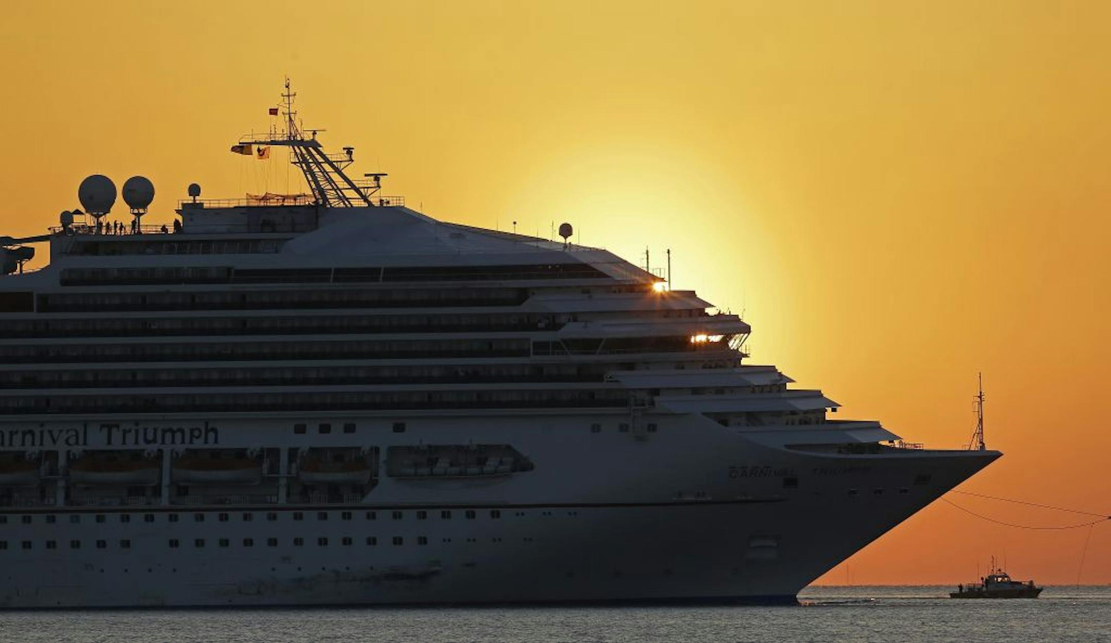 The cruise ship Carnival Triumph is towed into Mobile Bay near Dauphin Island, Ala., Thursday, Feb. 14, 2013. The ship with more than 4,200 passengers and crew members has been idled for nearly a week in the Gulf of Mexico following an engine room fire.