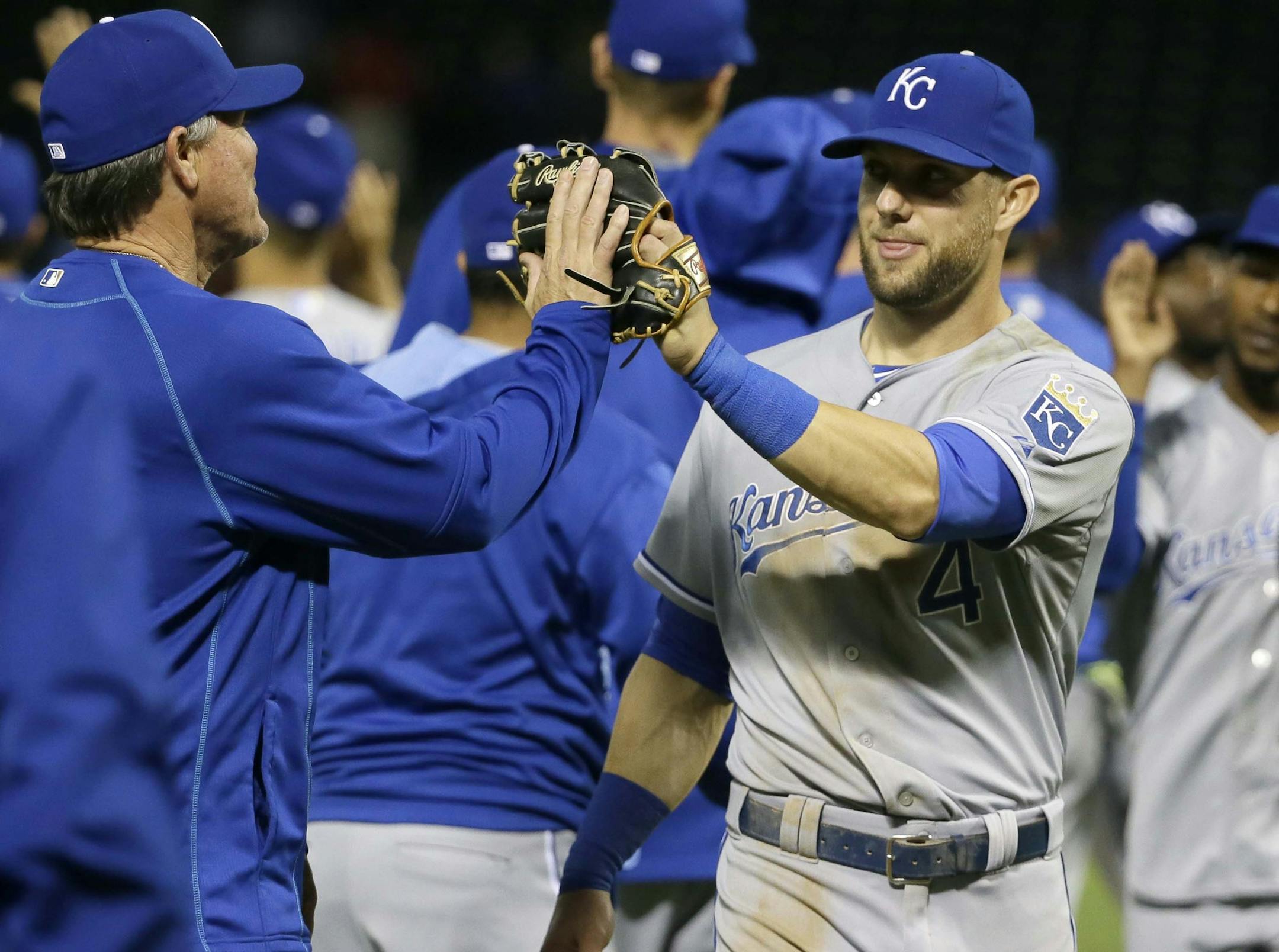 Kansas City Royals left fielder Alex Gordon (4) is congratulated by manager Ned Yost, left, after the final out in baseball game against the Texas Rangers in Arlington, Texas, Tuesday, May 12, 2015. The Royals won 7-6 in 10 innings. (AP Photo/LM Otero)