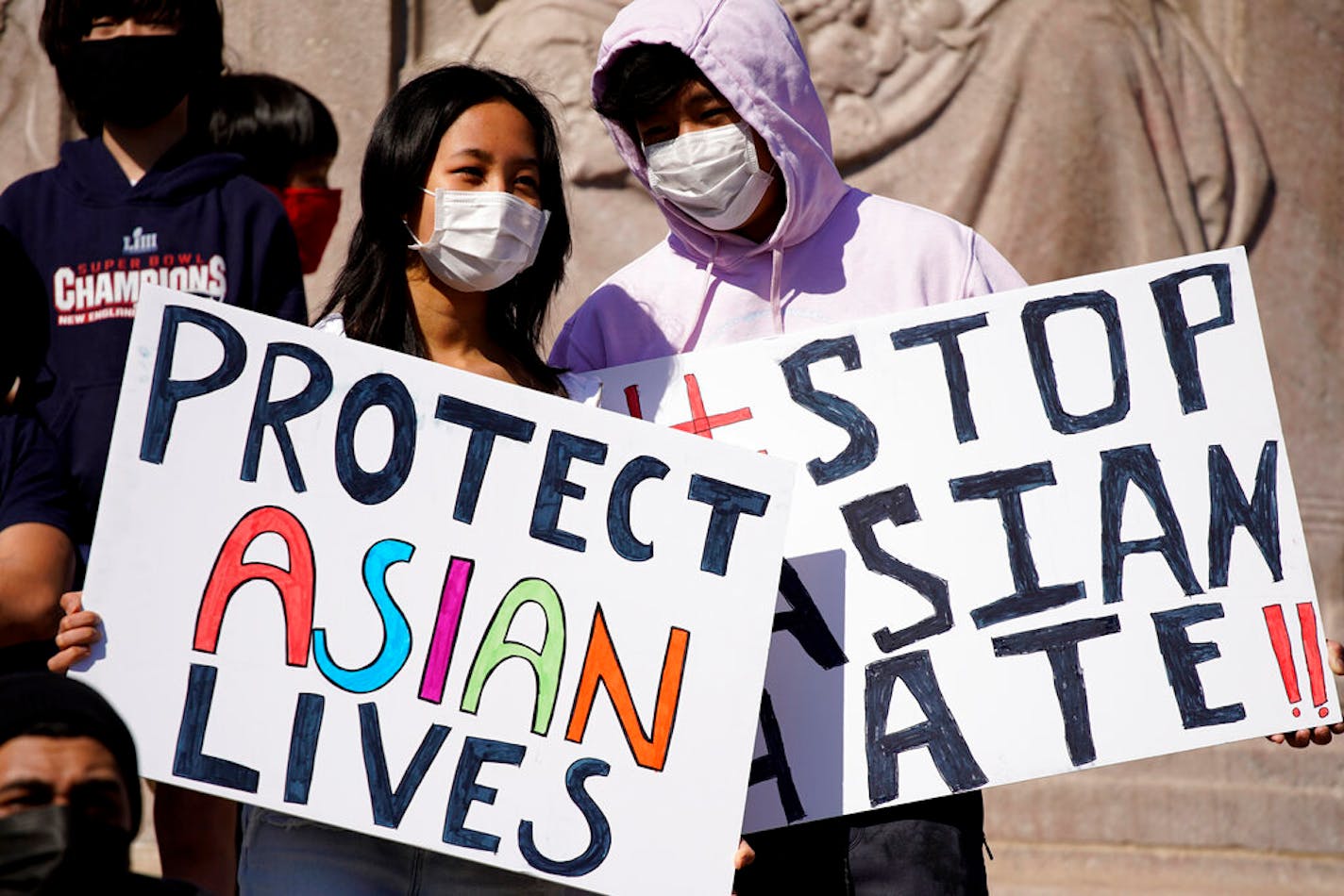 FILE - This March 20, 2021, file photo shows people holding signs as they attend a rally to support Stop Asian Hate at the Logan Square Monument in Chicago. A national coalition of civil rights groups will release on Wednesday, July 28, 2021, a comprehensive, state-by-state review of hate crime laws in the United States. Members of the coalition say the report sets the stage for bolstering the efficacy of current law and addresses racial disparities in how the laws are enforced. (AP Photo/Nam Y. Huh, File)