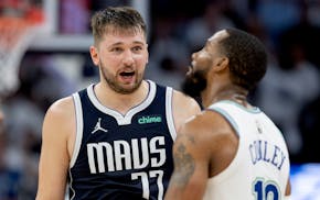 Mavericks guard Luka Doncic talks with Wolves guard Mike Conley in the fourth quarter of Game 1 of the Western Conference finals at Target Center.