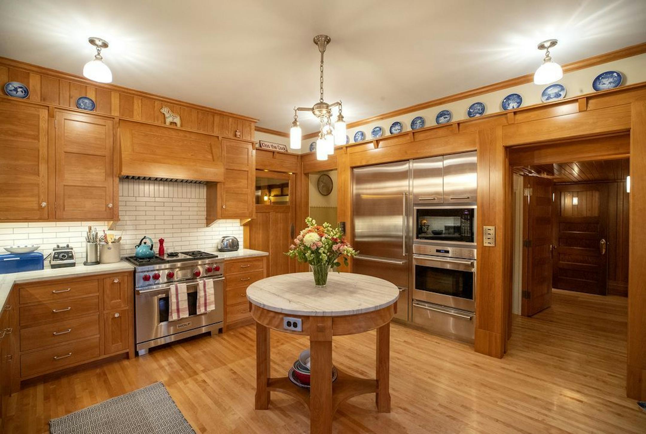 The new kitchen has a round, furniture-inspired island and display space for the family's collection of Danish Christmas plates.