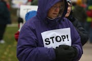 Kathy Lauwagie, of Maplewood, braved the cold and wind along with more than 100 other protesters to march for the resignation of Archbishop John Niens