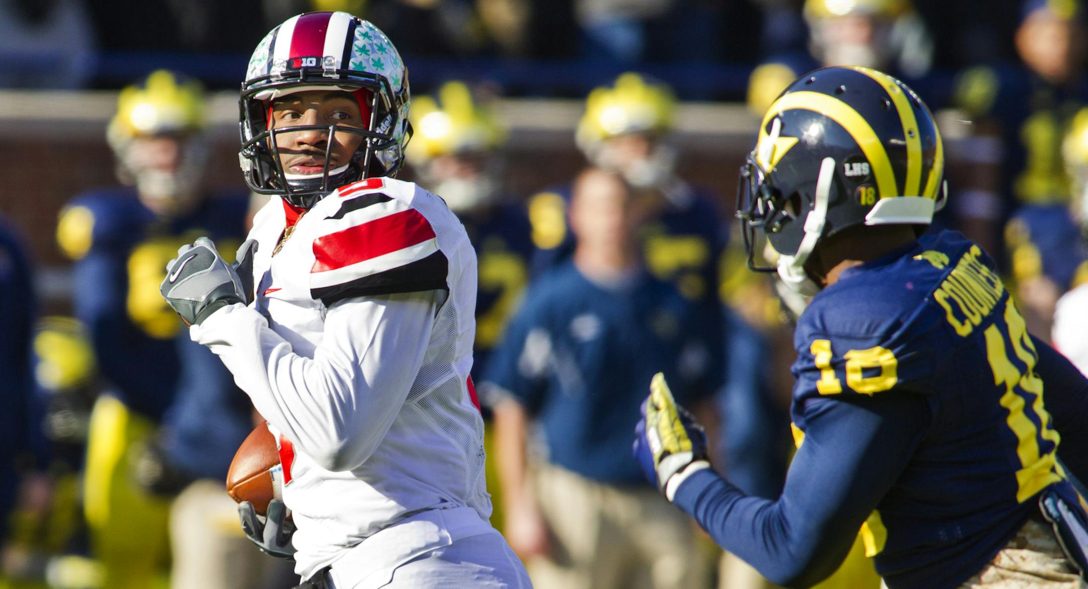 Ohio State quarterback Braxton Miller (5) looks back at Michigan defensive back Blake Countess (18) as he rushes for a touchdown in the first quarter of an NCAA college football game in Ann Arbor, Mich., Saturday, Nov. 30, 2013. (AP Photo/Tony Ding)