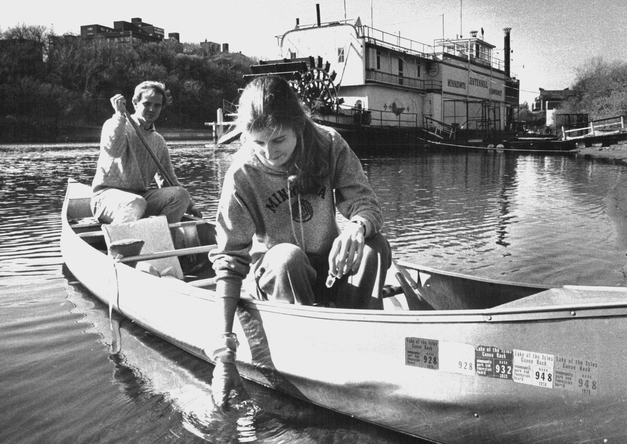 November 3, 1975 Joyce Warkentien, a member of the Minnesotans Against Pollution, took a sample of the Mississippi River water near the University of Minnesota, while Richard Young paddled the canoe. He Is a member of the Minnesota Public Interest Research Group, of which the pollution group is a part. A Northern States Power Co. (NSP) plant and city of Minneapolis sewage pipes appear to be the biggest local polluters of the Mississippi River, according to a river quality analysis sponsored Sund
