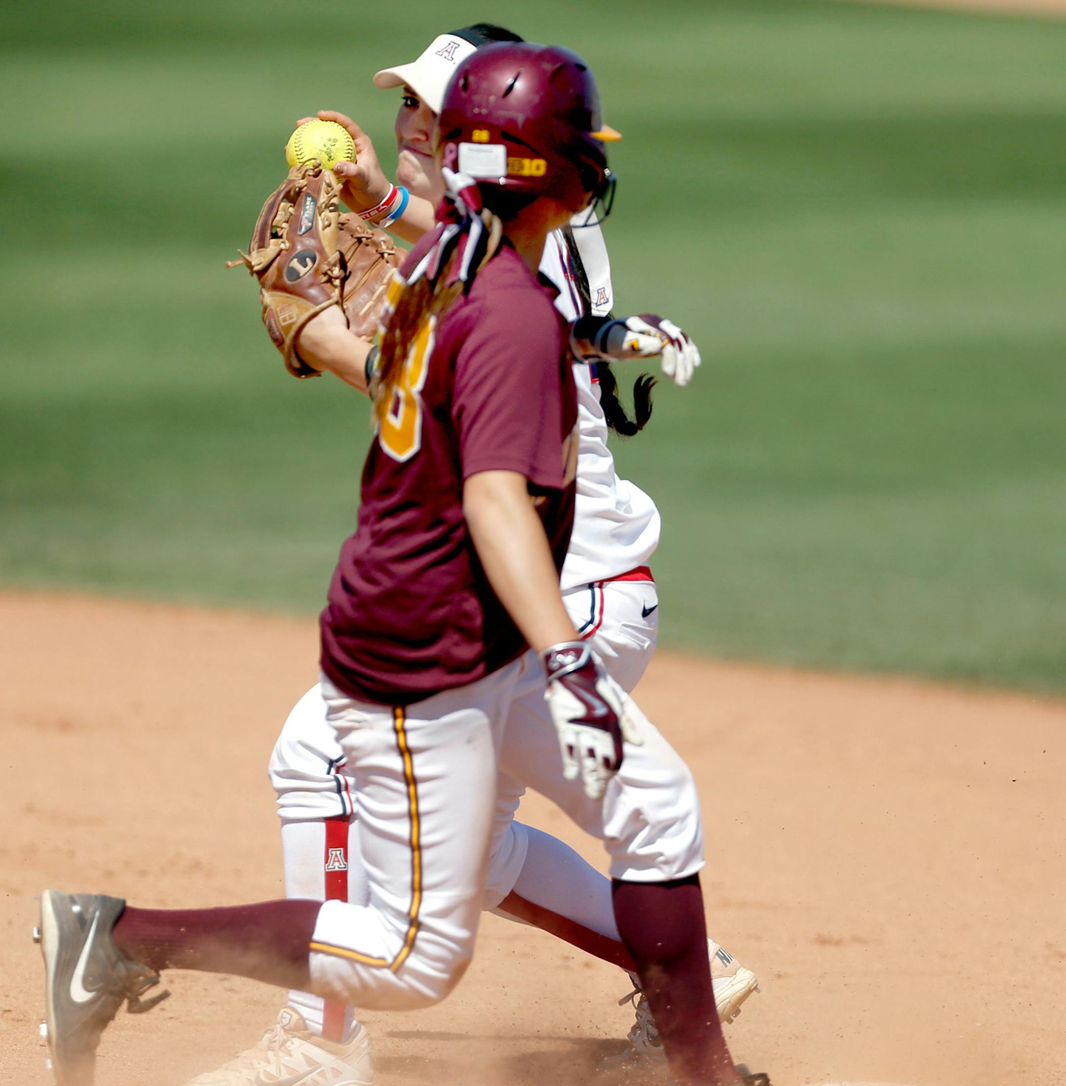 Minnesota's Danielle Parlich (28) does enough to break up a double play attempt, foiling Arizona second baseman Mo Mercado's (11) pivot throw in the seventh inning of their NCAA regional game at Hillenbrand Stadium, Saturday, May 16, 2015, Tucson, Ariz. Kelly Presnell / Arizona Daily Star