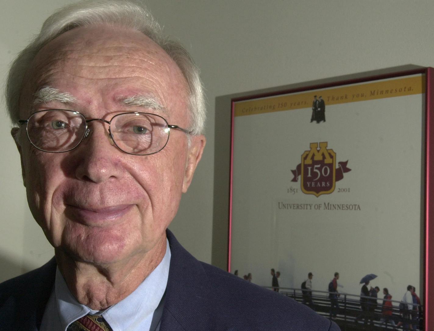 Heather Charles/ Staff Photographer St. Paul, MN: 7/14/04: Tom Swain, 83, stands in his office in Landmark Center in front of a poster for the University of Minnesota. Swain is one of six recipients of distinguished service awards from the National Governors Association.