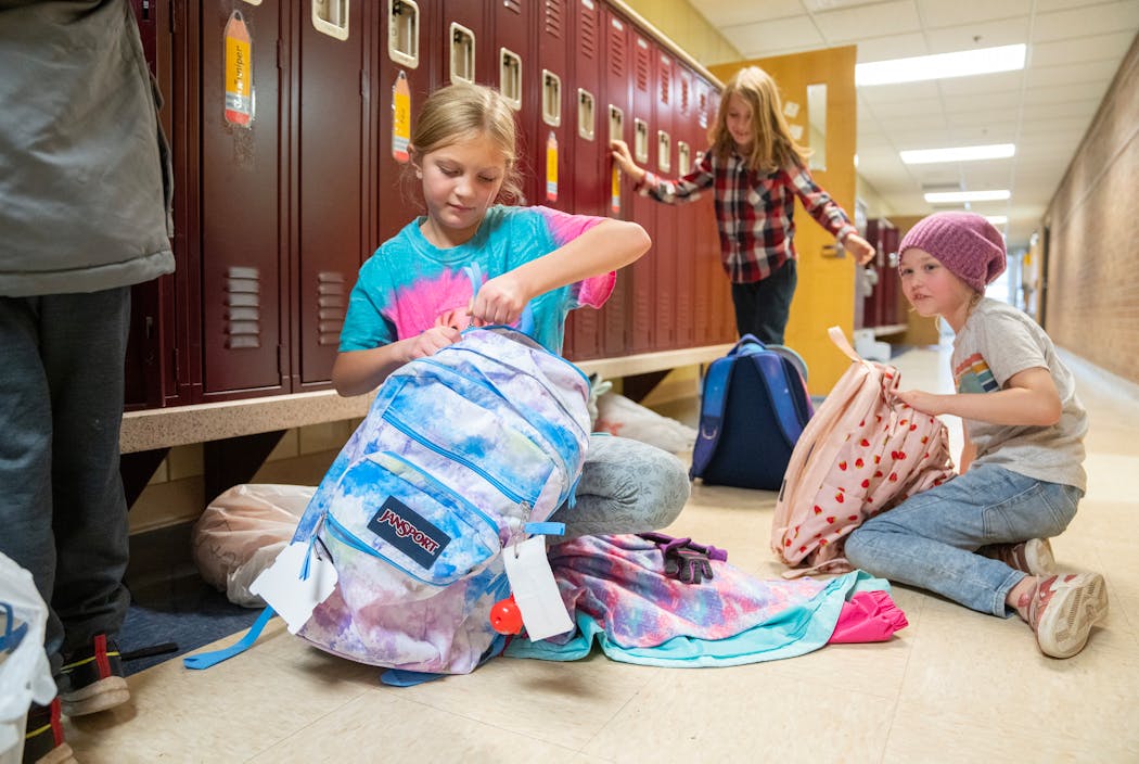 Third-graders Juniper Dohrmann, Flynn Nolte and Nia Howie-Petrosky packed their bags and put on outerwear at the end of the school day Friday at Marine Village School.