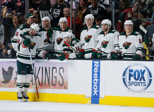 Players on the the Minnesota Wild bench react after Los Angeles Kings center Anze Kopitar scored in overtime during an NHL hockey game, Friday, Oct. 1