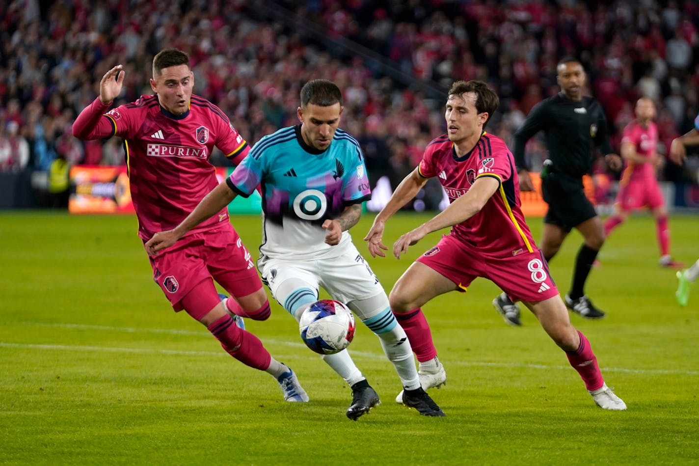 Minnesota United's Franco Fragapane, center, controls the ball as St. Louis City's Jared Stroud (8) and Jake Nerwinski defend during the first half Saturday