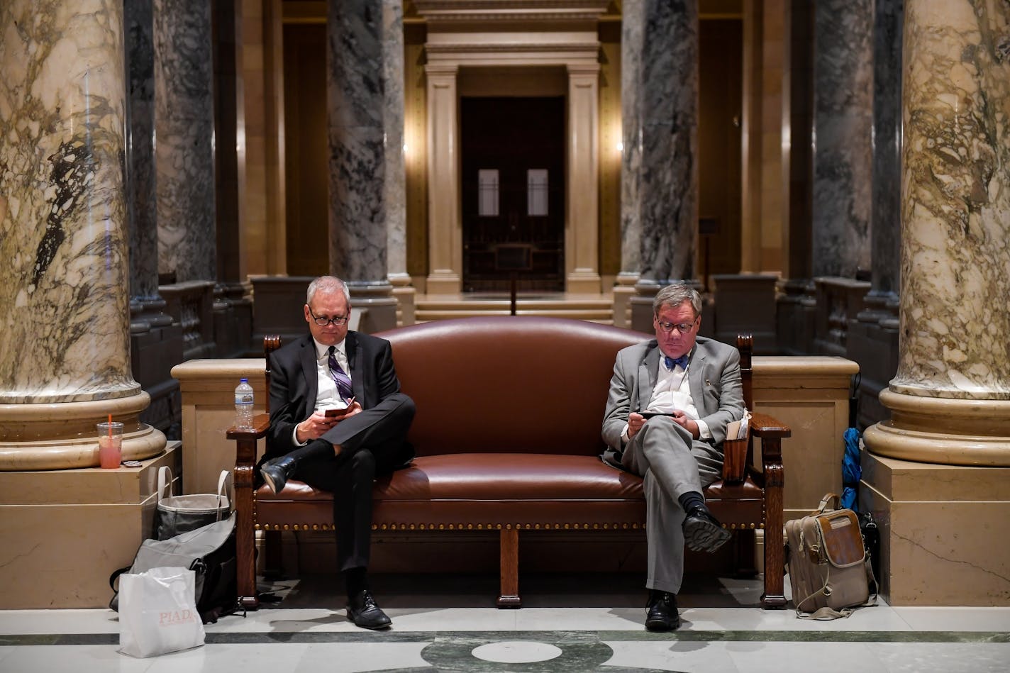 Brian Rice, right, a pension lobbyist, and Doug Anderson, director of the Public Employees Retirement Association, checked their phones during a recess in Tuesday night's legislative special session.