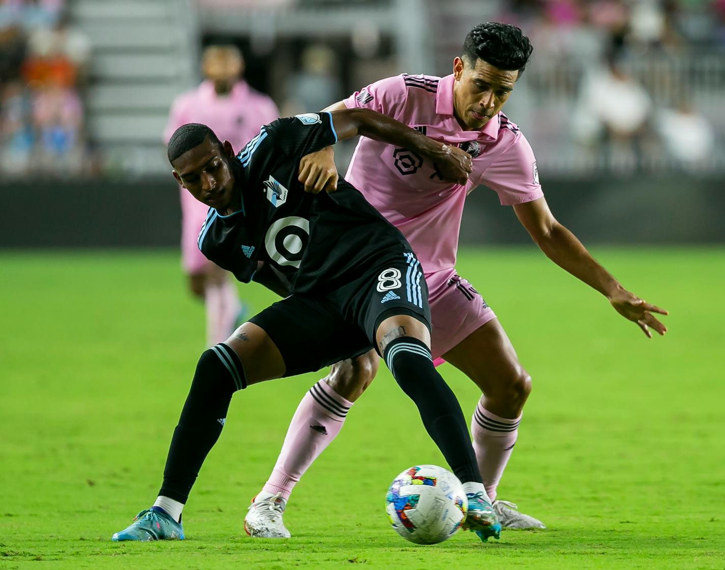 Inter Miami midfielder Victor Ulloa (13) fights for possession of the ball against Minnesota United midfielder Joseph Rosales (8) during the first half of an MLS soccer match Saturday, June 25, 2022, in Fort Lauderdale, Fla. (Matias J. Ocner/Miami Herald via AP)