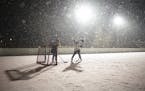 Sophie Korman and Joe Wocken played hockey in the falling snow Wednesday night on Lake of the Isles.