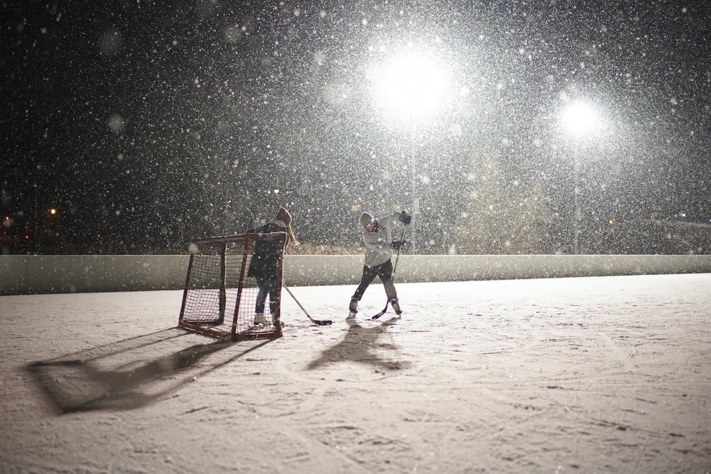 Sophie Korman and Joe Wocken played hockey in the falling snow Wednesday night on Lake of the Isles.