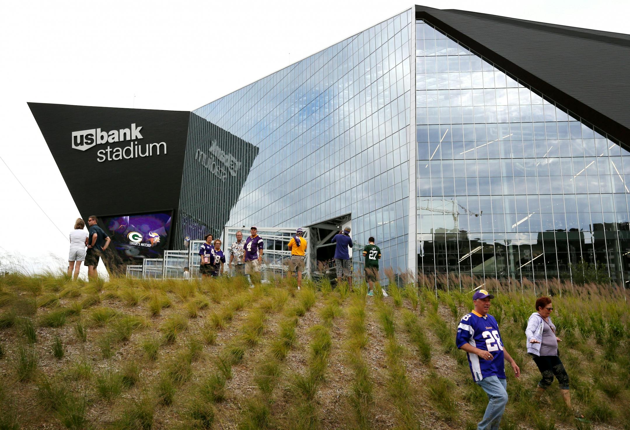 The Minnesota Vikings open the new US Bank Stadium for their first home regular season game against the Green Bay Packers. Here, fans climb the freshly landscaped hill outside the main entrance to the stadium.