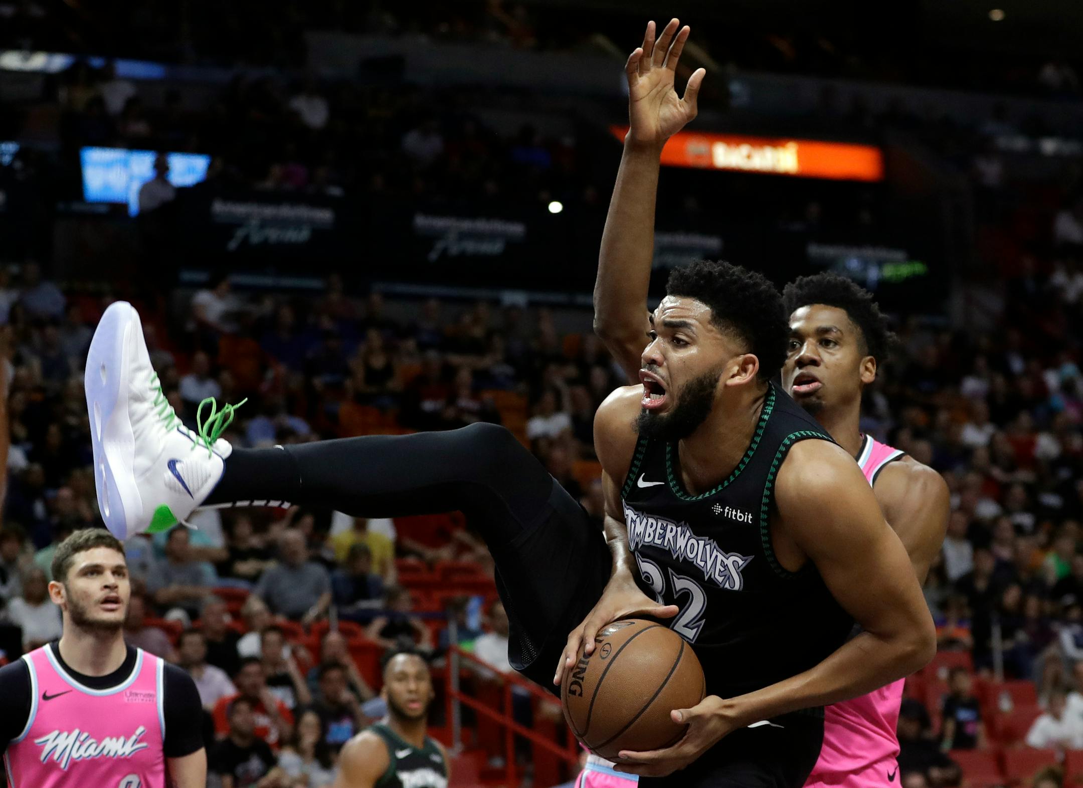 Timberwolves center Karl-Anthony Towns goes to the basket as Heat center Hassan Whiteside defends during the first half