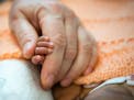 Kate Teague, a registered nurse at Lucile Packard Children's Hospital in Palo Alto, Calif., holds a premature baby's hand on Oct. 20, 2015. (Heidi de 