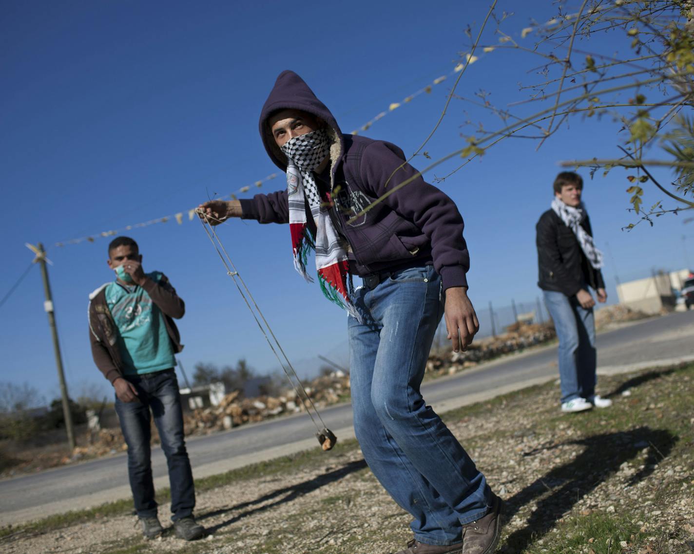 A Palestinian youth in the West Bank town of Nabi Saleh threw stones at Israeli soldiers during clashes that erupted after the funeral of Palestinian Mustafa Tamimi in 2011.