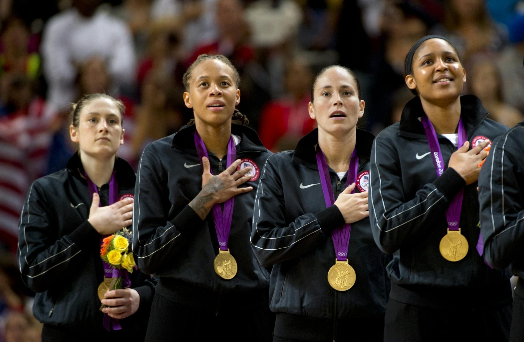 Minnesota Lynx players Lindsay Whalen (left) Seimone Augustus, Sue Bird (Not with lynx) and Maya Moore sing the national anthem after receiving their gold medals.