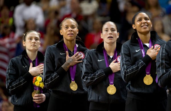 Minnesota Lynx players Lindsay Whalen (left) Seimone Augustus, Sue Bird (Not with lynx) and Maya Moore sing the national anthem after receiving their 