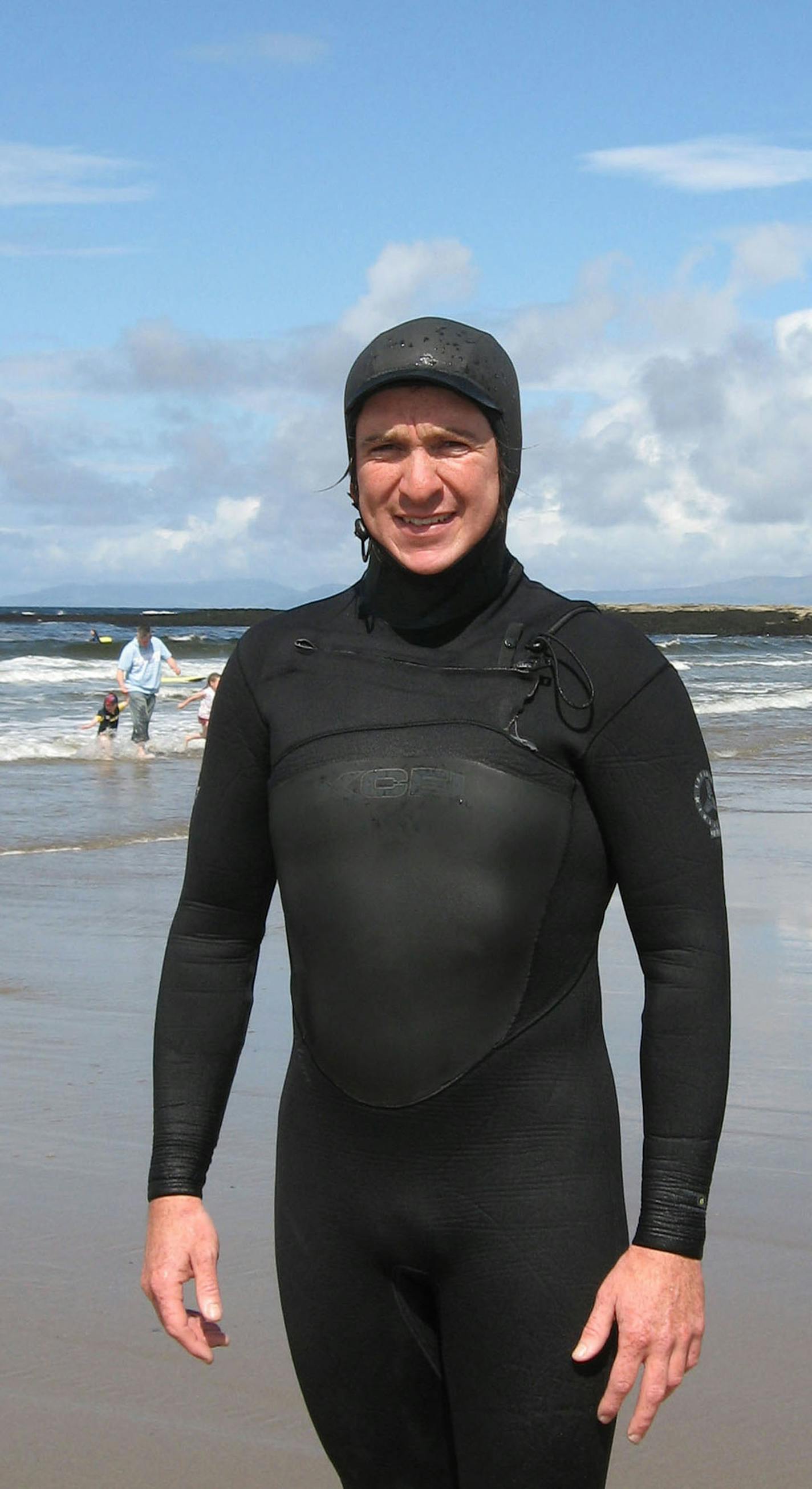 Andrew Hughes, an instructor with the Bundoran Surf Co., dresses in the head to toe wetsuit common among Irish surfers, even in the summer.