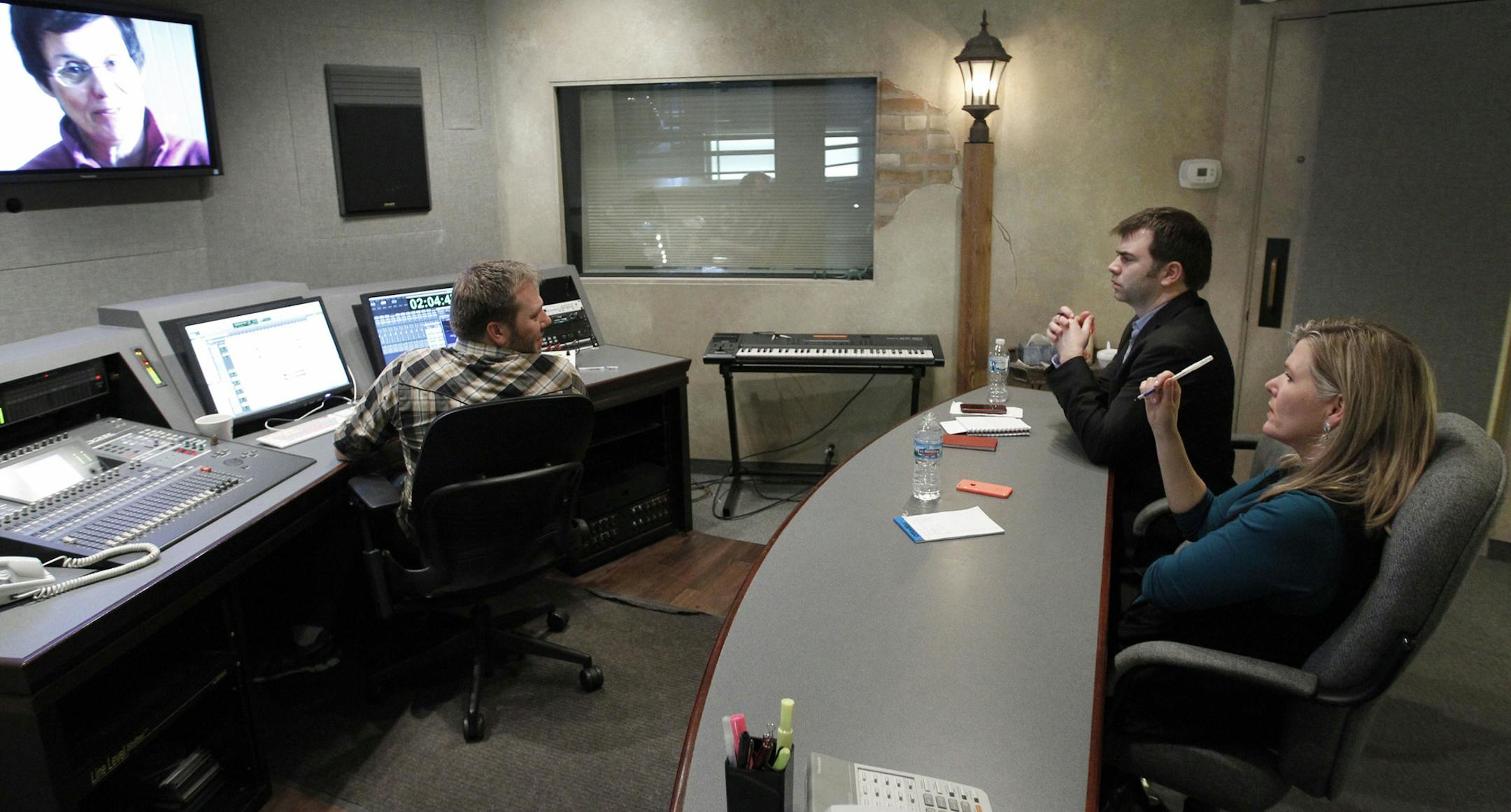 Minnesota artist Kirsten Lowe, right, co-producer Brian Forrest, and sound designer Jason Almendigner, left, work on a final sound-tweek of "Painting the Place Between" in Minneapolis, Monday, Nov. 25, 2013. ( Photo/Ann Heisenfelt) ORG XMIT: abbe2
