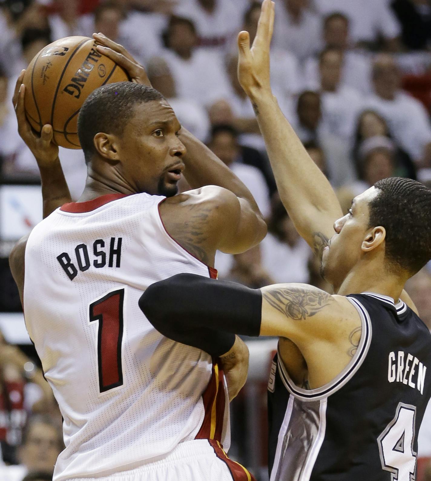 Miami Heat center Chris Bosh (1) looks to pass as San Antonio Spurs guard Danny Green (4), during the first half in Game 3 of the NBA basketball finals, Tuesday, June 10, 2014, in Miami. (AP Photo/Wilfredo Lee)