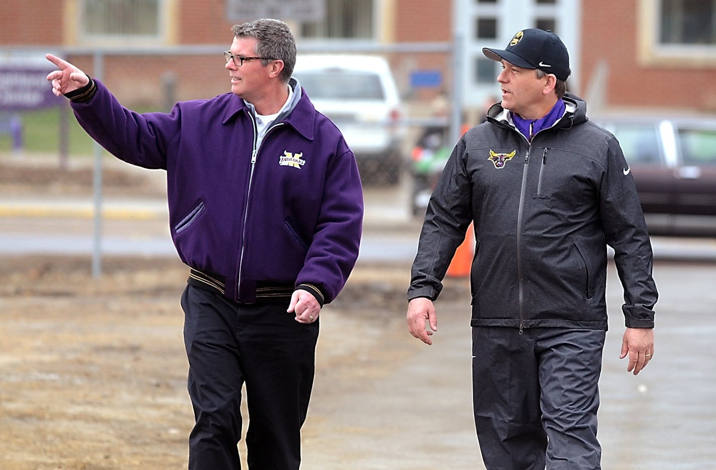 Minnesota State, Mankato athletic director Kevin Buisman, left, walks with football coach Todd Hoffner before Hoffner's first practice after being reinstated as coach, Wednesday, April 16, 2014.