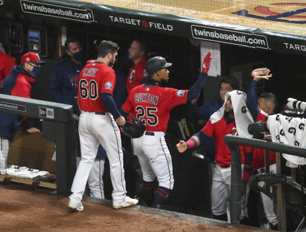 Minnesota Twins center fielder Byron Buxton (25) and right fielder Jake Cave (60) celebrated with teammates after a two-run home run hit by Buxton in 