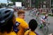 From left, Destinee Turner, Cyrus Palmer, 13, and Willie Jordan, 12, watch racers turn the corner of Holmes Avenue and W 31st Street during stage four