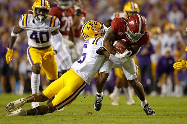 Alabama running back Jahmyr Gibbs, right, is tackled by LSU safety Jay Ward (5) during a game in November.
