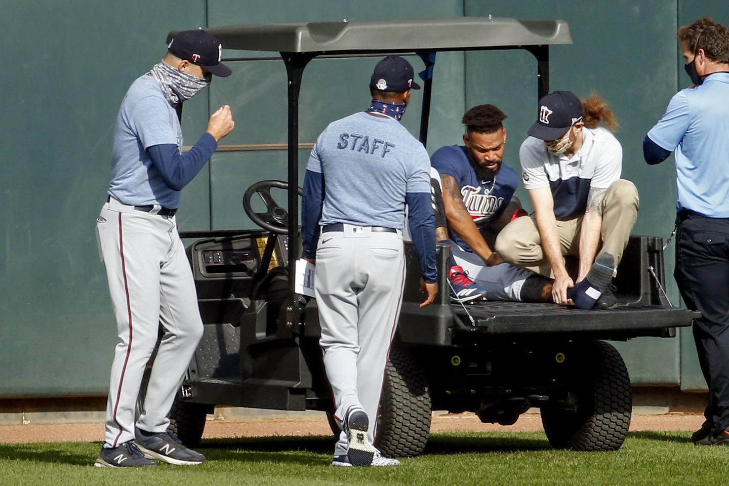 Twins manager Rocco Baldelli, left and coach Tony Diaz, second from left, watch as assistant athletic trainer Matt Biancuzzo, second from right, steadies the ankle of Byron Buxton