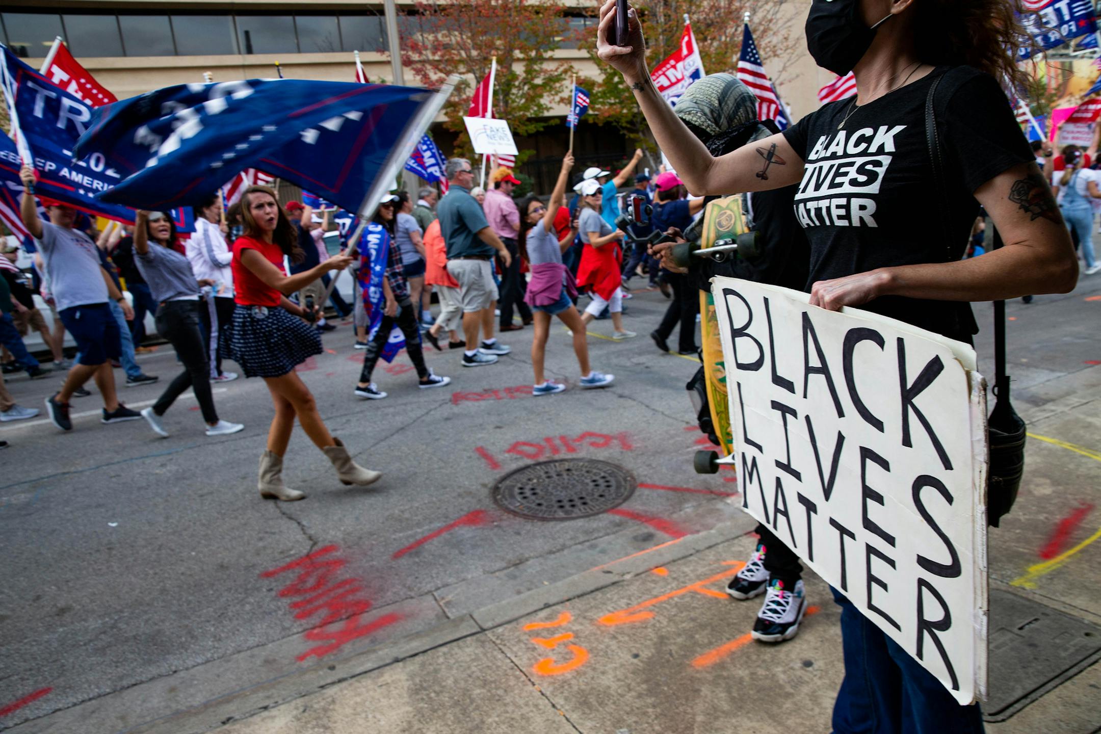 Demonstrators in support of President Donald Trump march by someone holding a Black Lives Matter sign during a Don't Steal the Vote rally in downtown Dallas on Saturday, Nov. 14, 2020. (Juan Figueroa/Dallas Morning News/TNS) ORG XMIT: 1829257