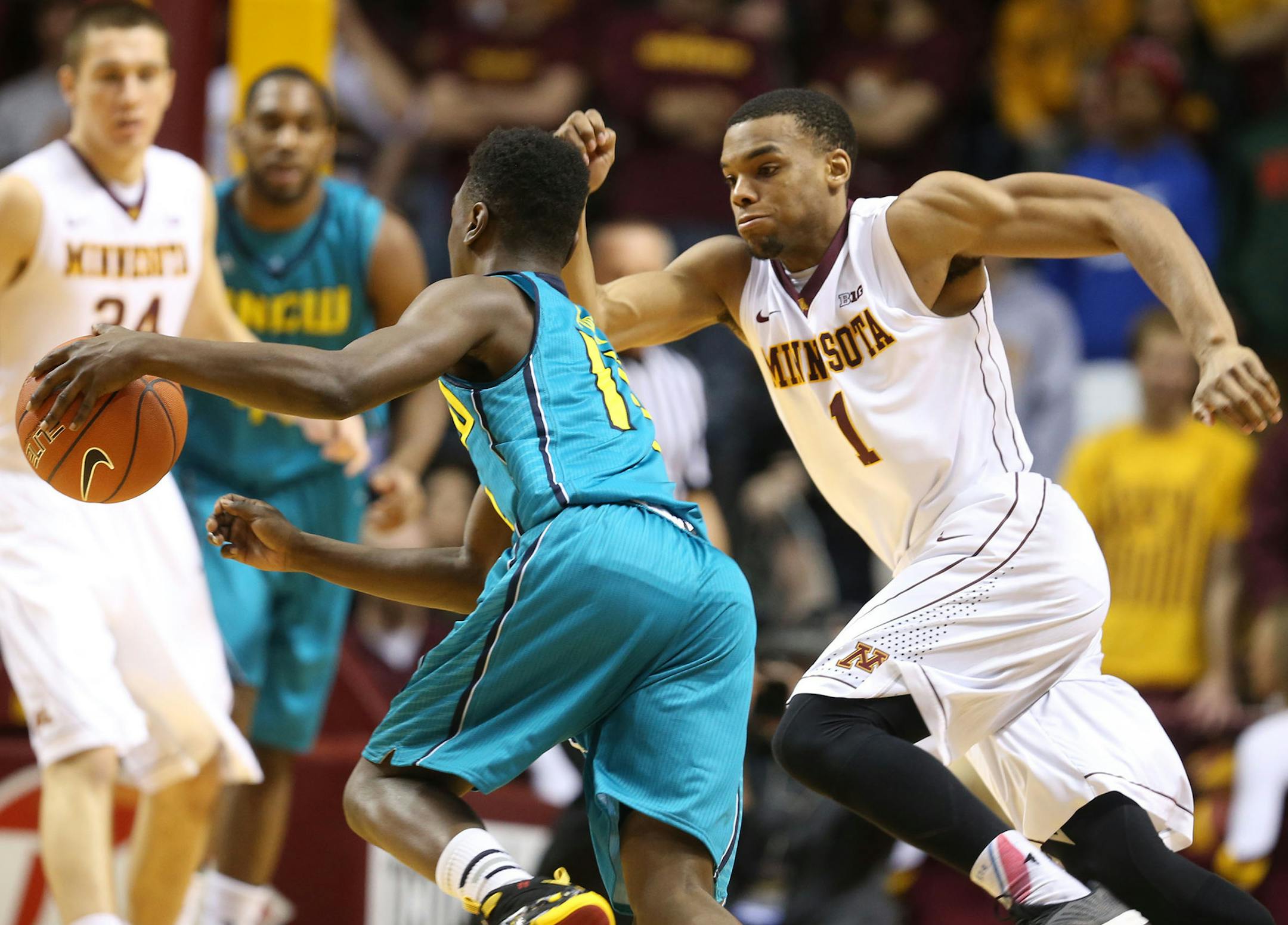 Minnesota's Andre Hollins (1) pressures UNC Wilmington's Chuck Ogbodo (13) during the second half of the Gophers' 108-82 win Saturday, Dec. 27, 2014 at Williams Arena in Minneapolis.