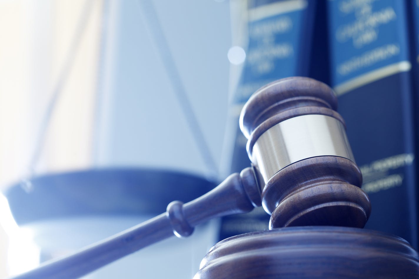 iStock
A gavel rests on its sounding block with a several law books and a justice scale out of focus in the background.