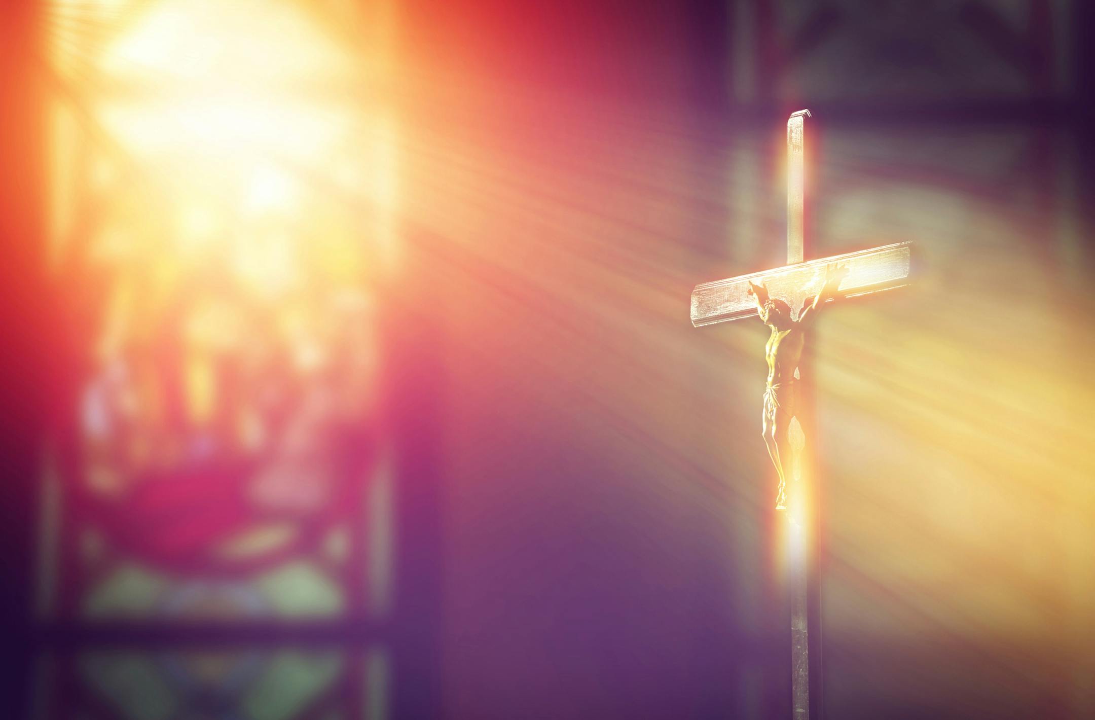iStock
Crucifix, Jesus on the cross in church with ray of light from stained glass.