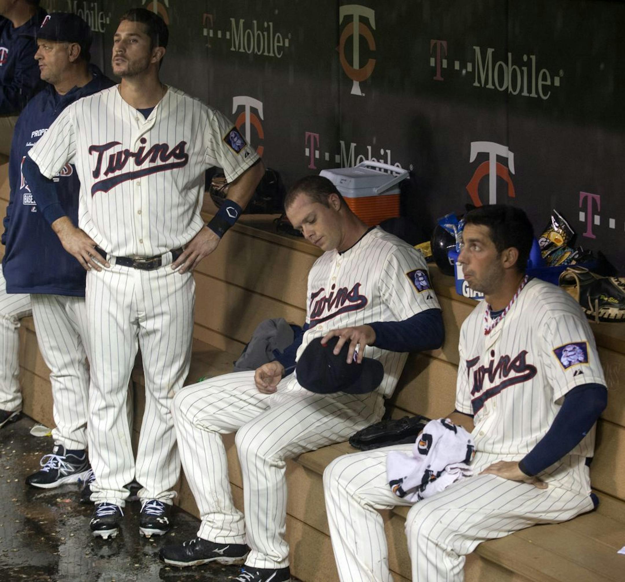 Minnesota Twins starting pitcher Andrew Albers, center, sits in the dugout with teammates Trevor Plouffe, left, and Chris Colabello, right, during a fourth inning rain delay of a baseball game against the Tampa Bay Rays, Saturday, Sept. 14, 2013, in Minneapolis.