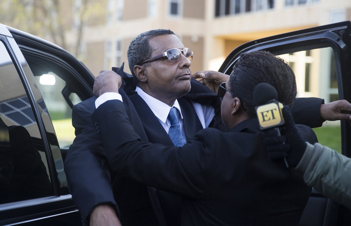 Prince's half-brother Alfred Jackson gets some help with his jacket as he arrives at the Carver County Courthouse.