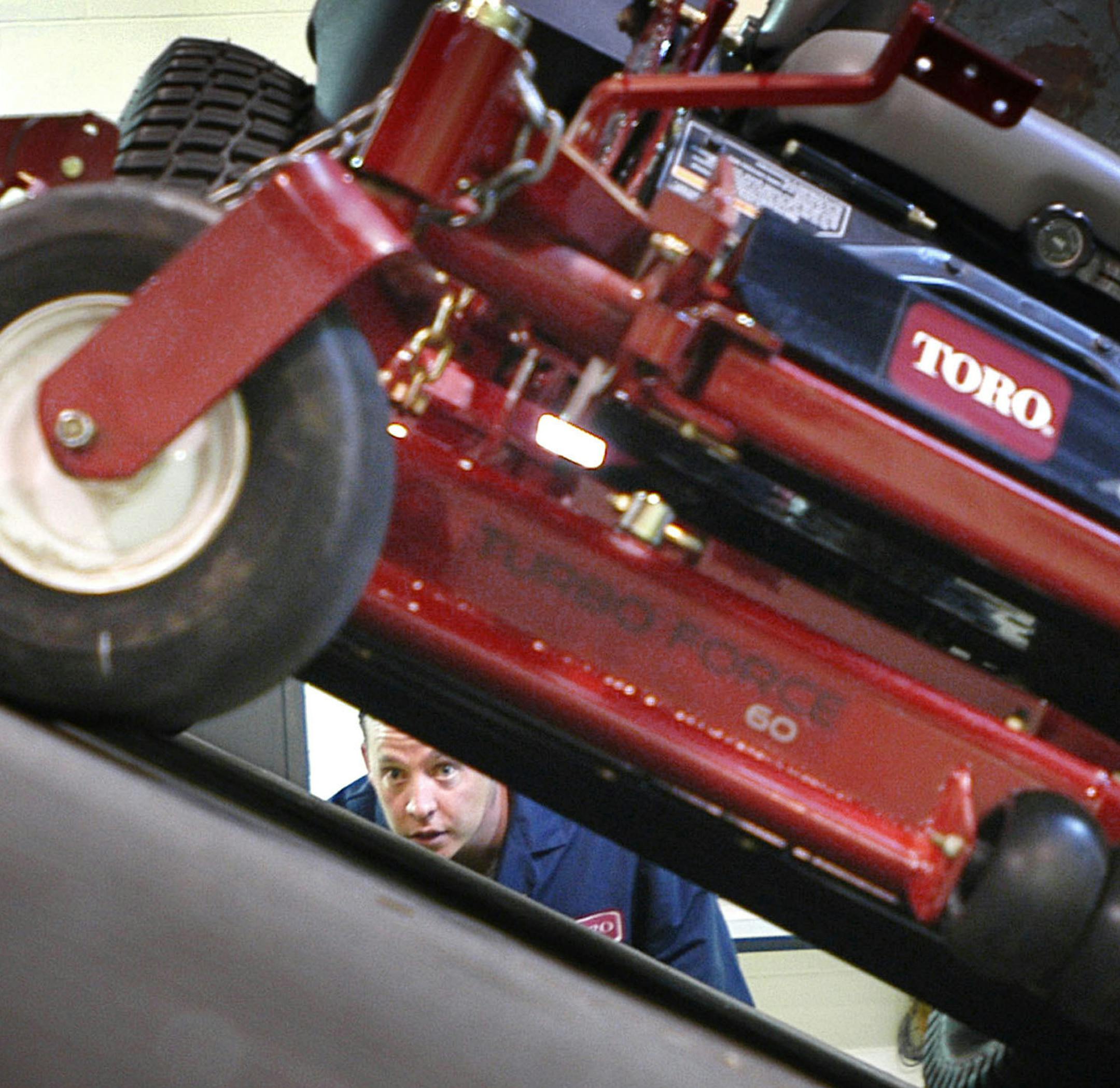 At Toro's Bloomington testing and research facility, test engineers John Coughlin, left, and Barry Hentges, right, peer under a Toro Z Master Commercial tractor prototype during a stability and hillside control test. EDS: This was part of an actual ongoing test and was not prearranged in any way. Source: Star Tribune; Origin: Minneapolis; Byline: Glen Stubbe; Object Name: Toro Testers; Category: General News ORG XMIT: MIN2013040116413654