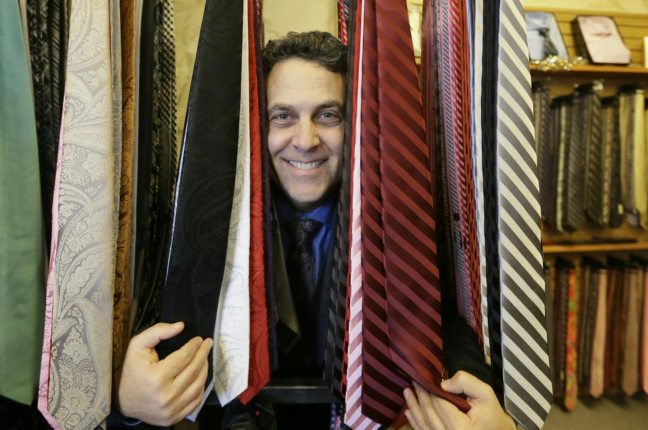 Rod Brown, co-owner of The Shirt Box, poses in his men's clothing store, Thursday, Dec. 3, 2015, in Farmington Hills, Mich. With the start of the holiday shopping season behind them and the big final push still to come, independent retailers have to get creative to bring customers in. The Shirt Box is holding events like bourbon tastings and giving lessons on tying bow ties on weekends during the holiday season, in an effort to get customers to shop at the store. (AP Photo/Carlos Osorio) ORG XMI