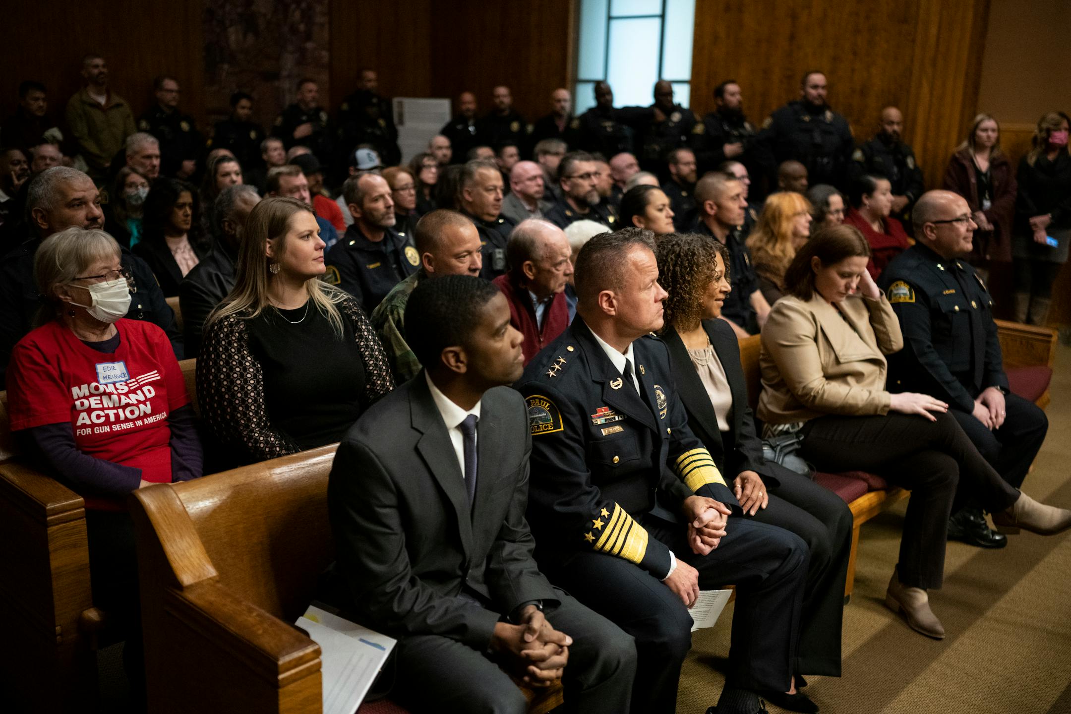 From left, St. Paul Mayor Melvin Carter, St. Paul Police Commander of Narcotics, Financial Intelligence and Human Trafficking Division Axel Henry and Henry's partner, Mikeya Griffin sit in the packed city council chambers while awaiting a vote confirming Henry as the city's new police chief Wednesday, Nov. 16, 2022 at St. Paul City Hall in St. Paul, Minn..