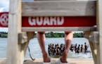A lifeguard watched as Gophers football players ran through the shallows of Lake Nokomis in 2017.