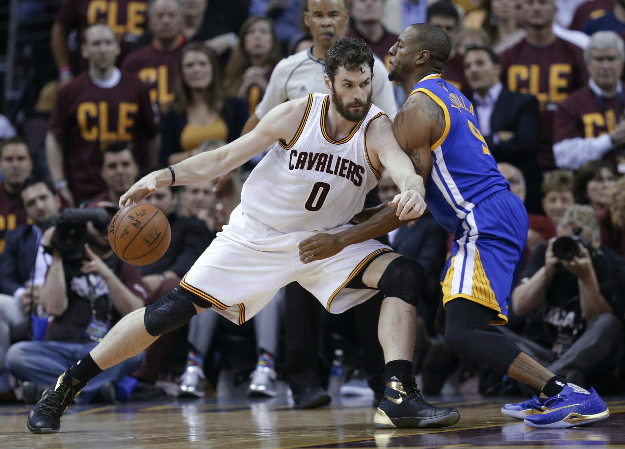 Cleveland Cavaliers forward Kevin Love (0) drives on Golden State Warriors forward Andre Iguodala (9) during the first half of Game 4 of basketball's NBA Finals in Cleveland, Friday, June 10, 2016. (AP Photo/Tony Dejak)