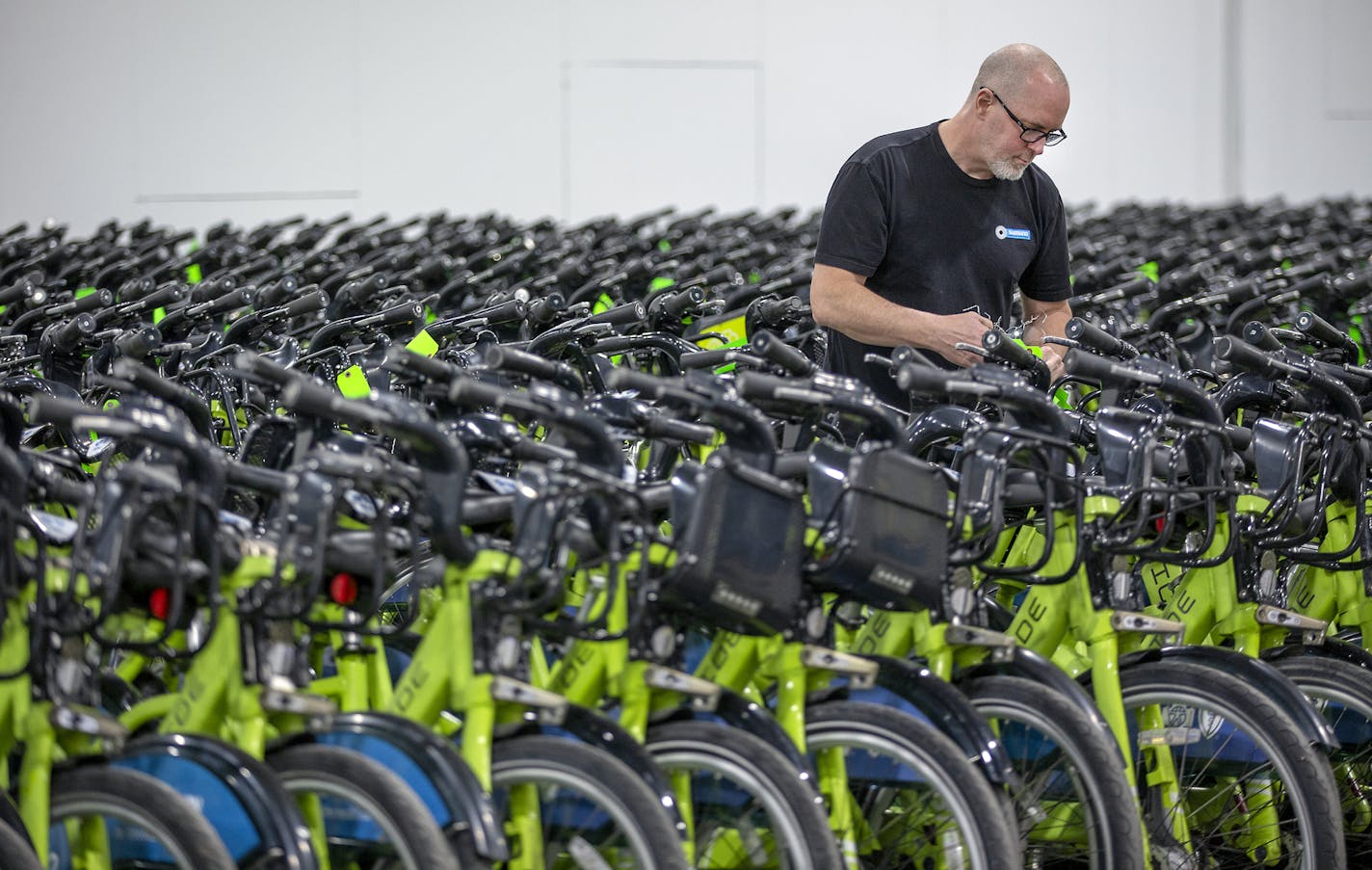 Sean Davis of Nice Ride worked at taking tags off bikes as the company rolled out its fleet throughout Minneapolis, Monday, April 22, 2019 in Minneapolis, MN. They planned to distribute 1800 green docked bikes and 1500 blue deckles bikes. ] ELIZABETH FLORES &#x2022; liz.flores@startribune.com