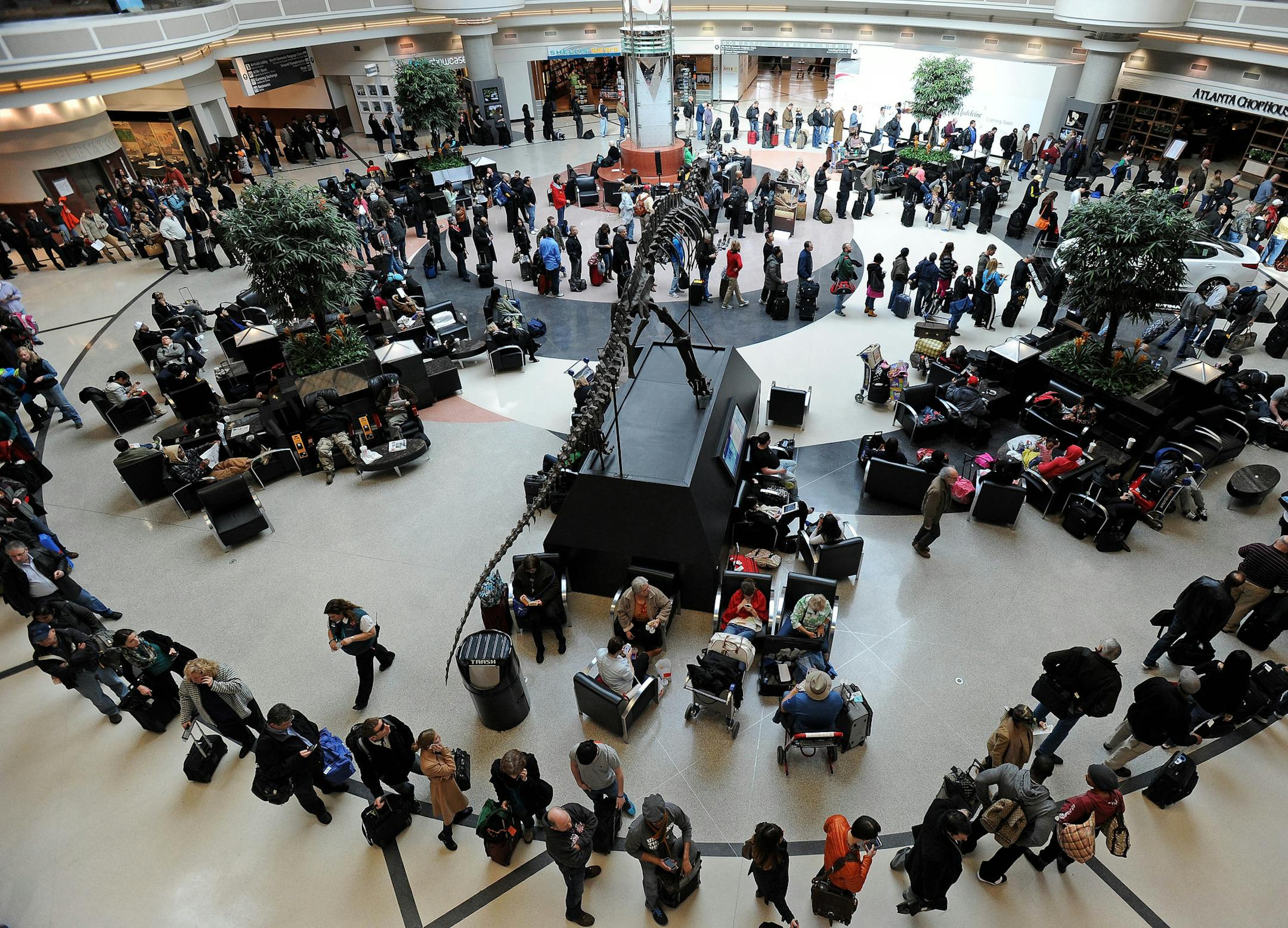 A long line of travelers winds around the atrium at Hartsfield-Jackson International Airport when operations return after the effects of a major winter storm halted flights for three days, on Thursday, Feb. 13, 2014, in Atlanta. (AP Photo/David Tulis)