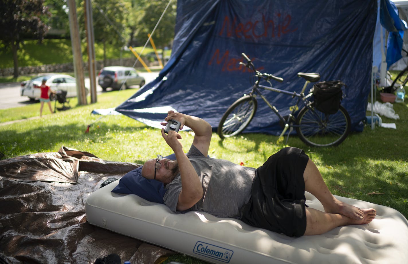 Jon, who declined to give his last name, watched a YouTube video on his phone to pass the time Wednesday afternoon in the encampment at Lyndale Farmstead Park in Minneapolis. ] JEFF WHEELER • Jeff.Wheeler@startribune.com As the encampment of homeless people at Powderhorn Park grew to greater numbers, smaller satellite encampments have begun to be established in other parks, such as Lyndale Farmstead in south Minneapolis. The Lyndale Farmstead camp, which began on Sunday, is just steps away from