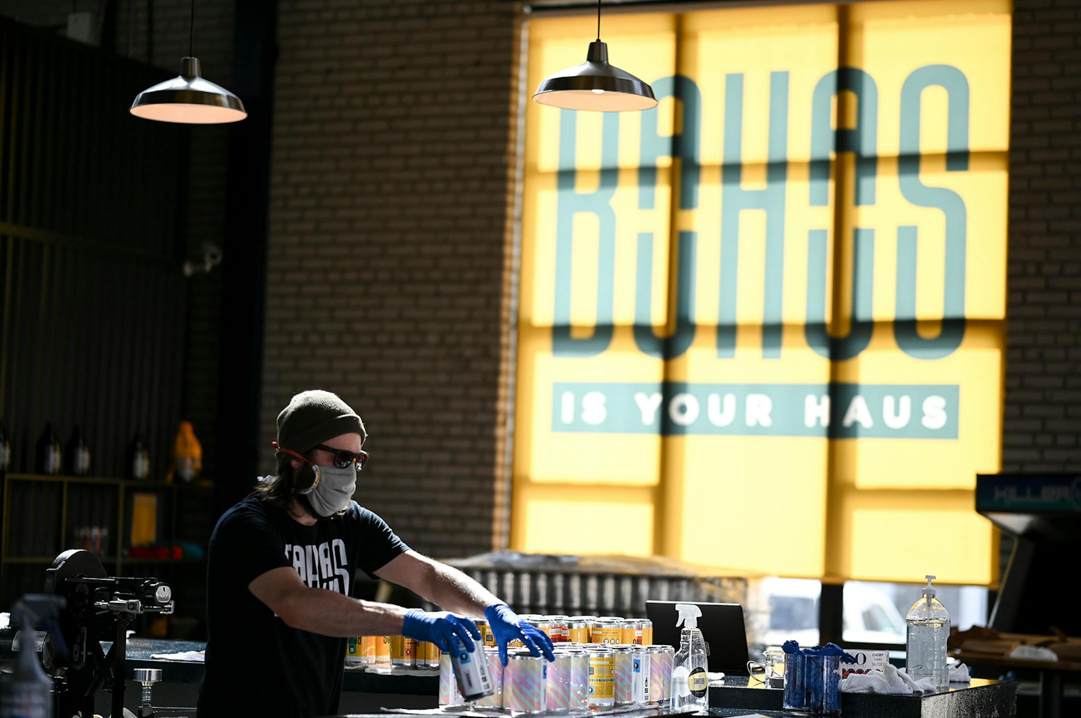 Bauhaus brewer Dan Larsen dried off crowlers after sealing them Friday while fulfilling pick up orders. Despite strong sales of wine, spirits and beer in liquor stores since COVID-19 hit, craft breweries in Minnesota and other states have taken a body blow, especially the smaller breweries that produce less than 1,000 barrels annually.