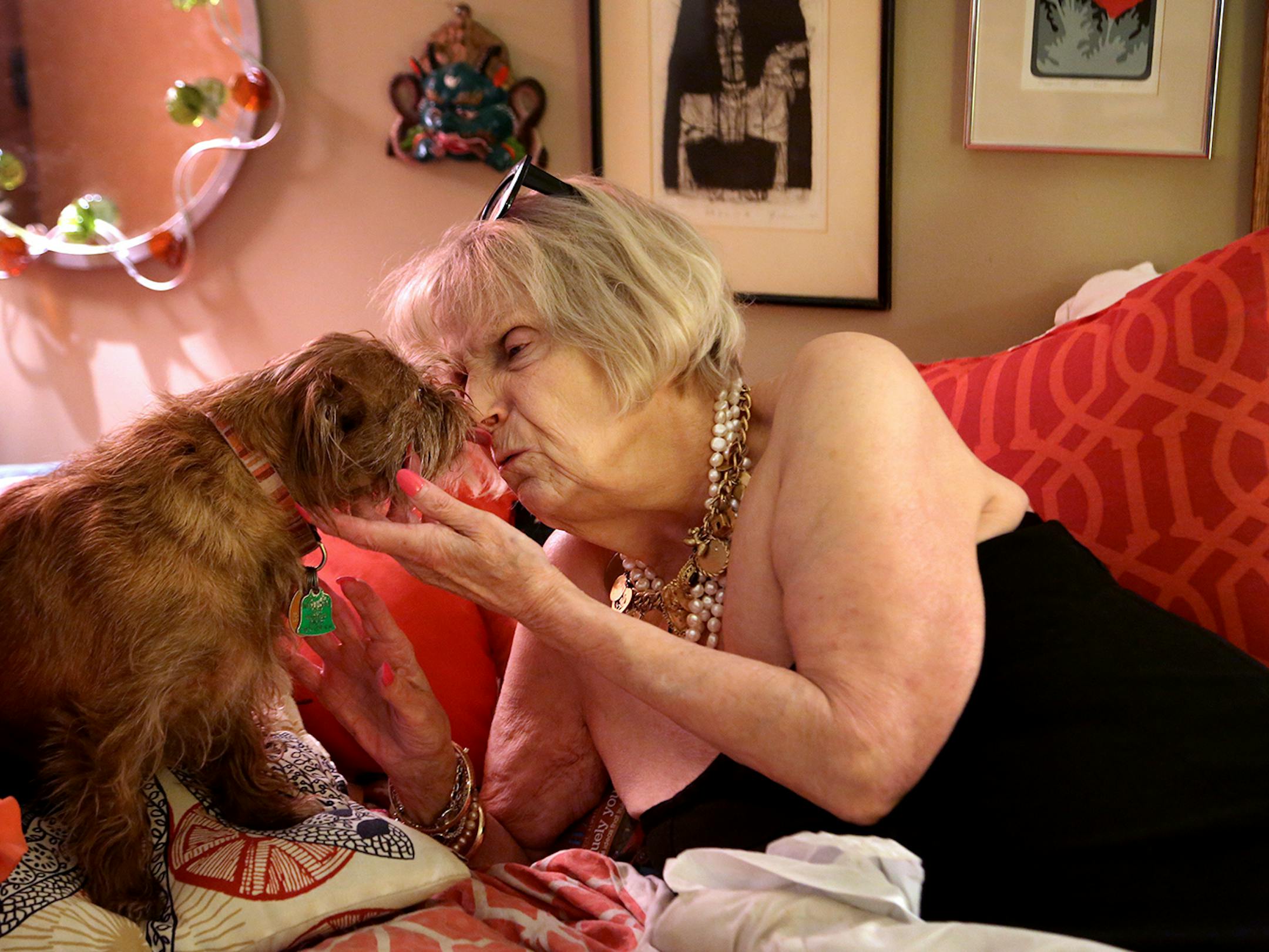Carlson gets a kiss from one of her two dogs while pausing from getting ready for a game of Mah Jongg with friends at a restaurant in Wayzata.
