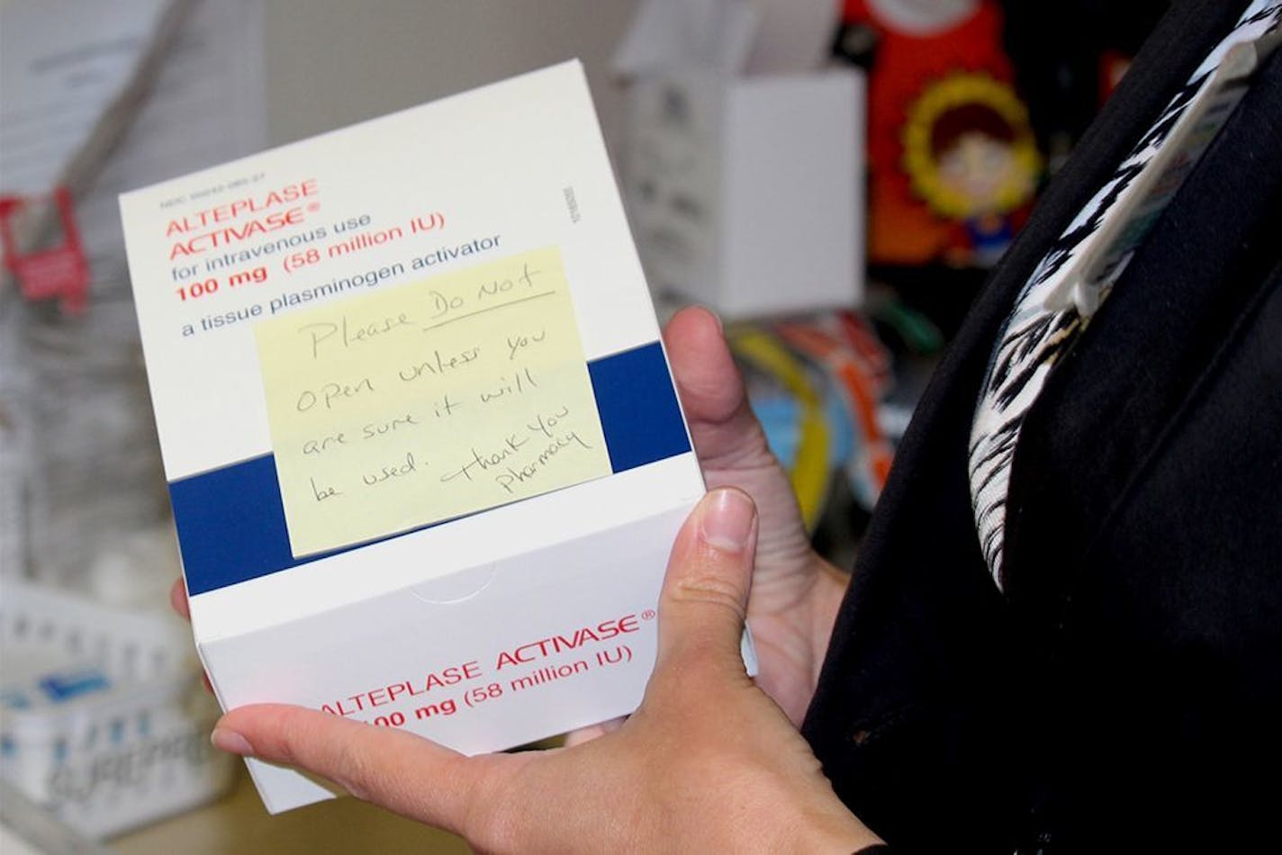 Stone County pharmacist Mandy Langston holds a box of Activase in the hospital's emergency department. Langston, concerned about the clot-busting drug's $8,000 price tag, penned a handwritten sticky note that reads: "Please do not open unless you are sure it will be used. Thank you, Pharmacy."