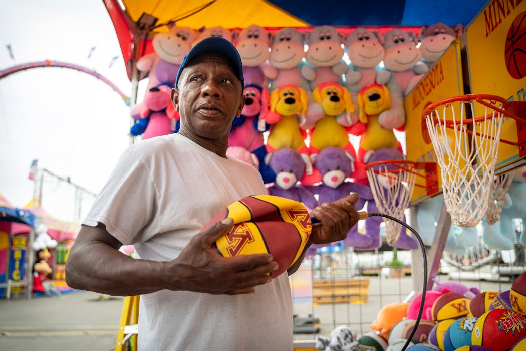 Wayne Davis from Columbus, Ohio, inflated a University of Minnesota basketball, one of the prizes at a midway booth. At this point, Davis had blown up 535 basketballs in preparation for the fair.